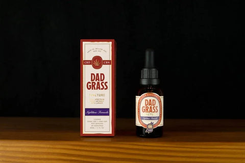 Dad Grass Nighttime Formula CBD and CBN tincture bottle and packaging on a wooden surface.